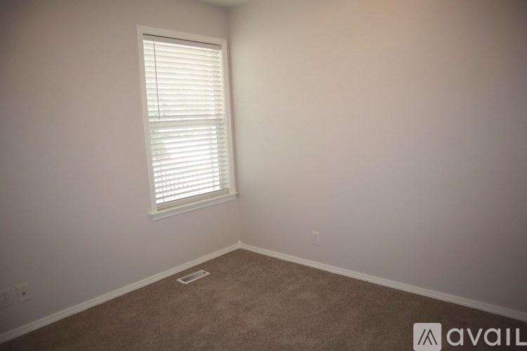A room with a window and carpeted floor.
