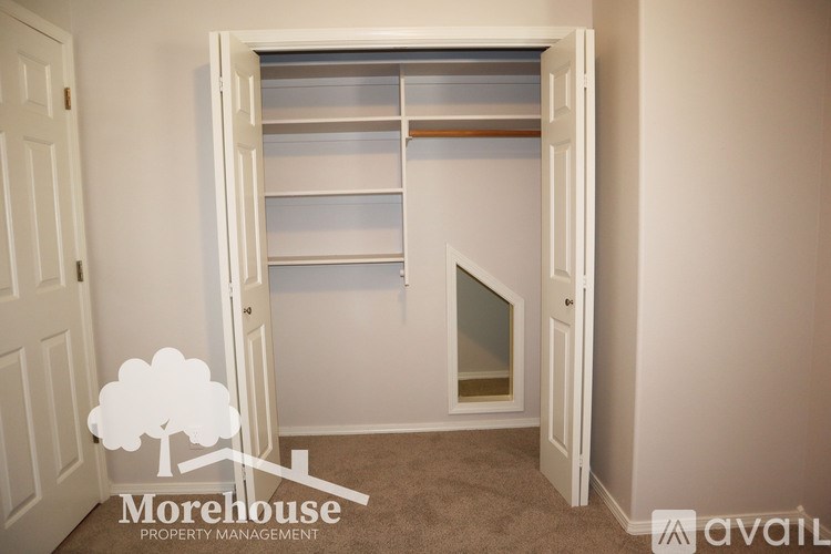 A white closet with a mirror and shelves is shown.
