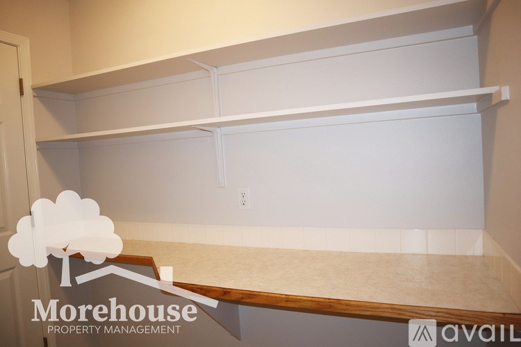 A white empty room with Morehouse Property Management logo.