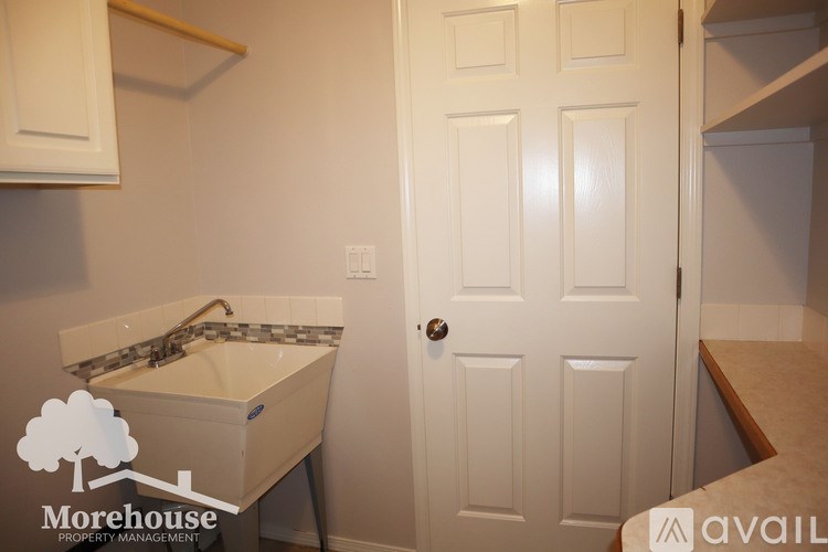 A white door is in a room with a sink and a cabinet.