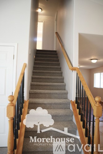 A staircase with a carpeted runner and wooden balusters.