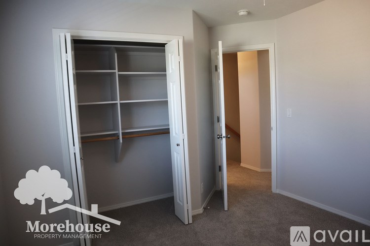 A room with a white door and a grey carpet.