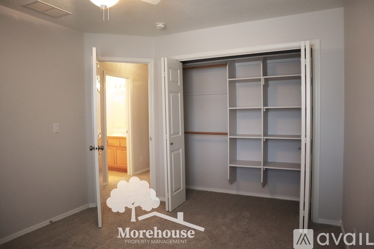 A room with a white door and a wall shelf.