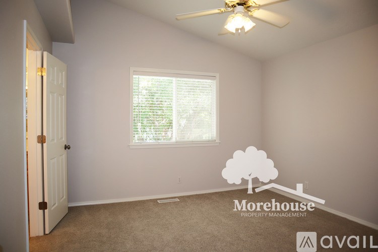 A room with a ceiling fan and a window with blinds.