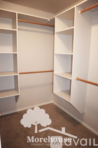 A Morehouse Property Vault image of a white closet with shelves and a brown carpet.