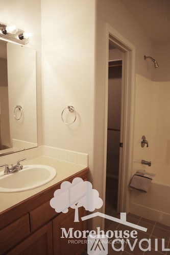 A bathroom with a sink, mirror, and toiletries.