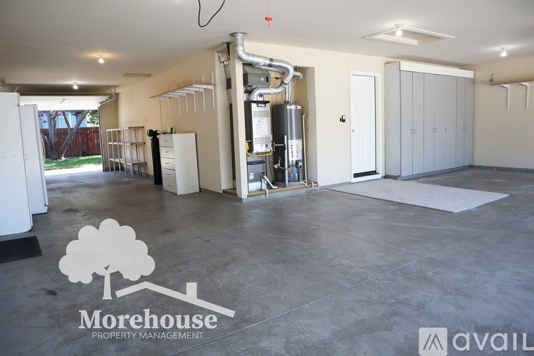 A spacious room with a Morehouse Property Management logo on the floor.