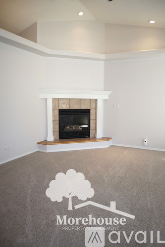 A living room with a fireplace and a logo on the floor.