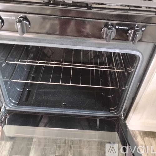 A clean oven with a glass door and a metal rack inside.