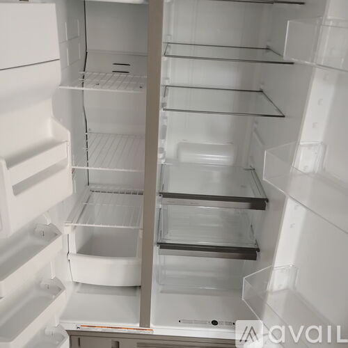 A white refrigerator with all shelves empty.