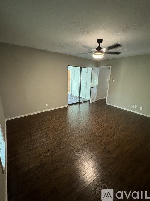 A room with wooden flooring and a ceiling fan.