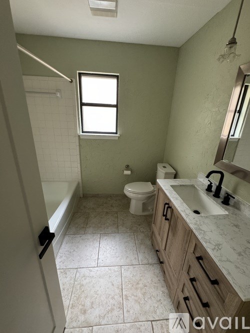 A bathroom with a toilet, sink, and bathtub.