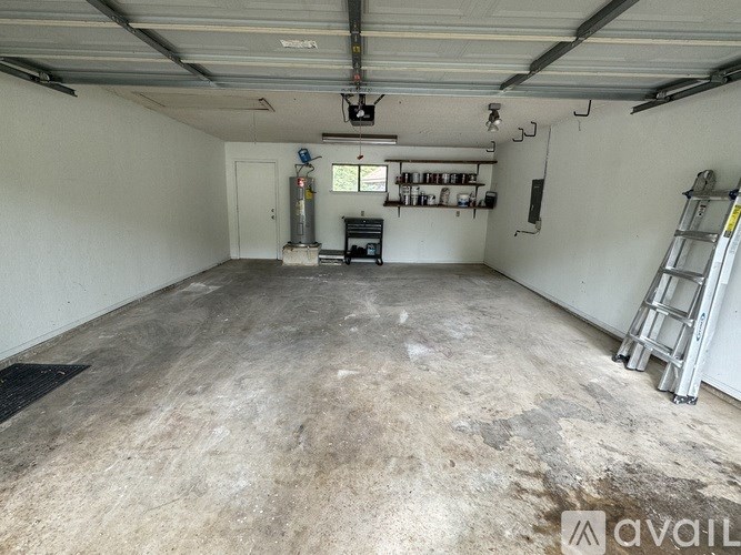 A large, empty garage with a concrete floor and white walls.