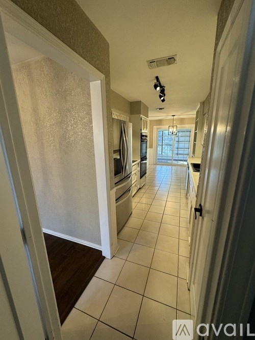 A hallway with a tiled floor and a light on the ceiling.