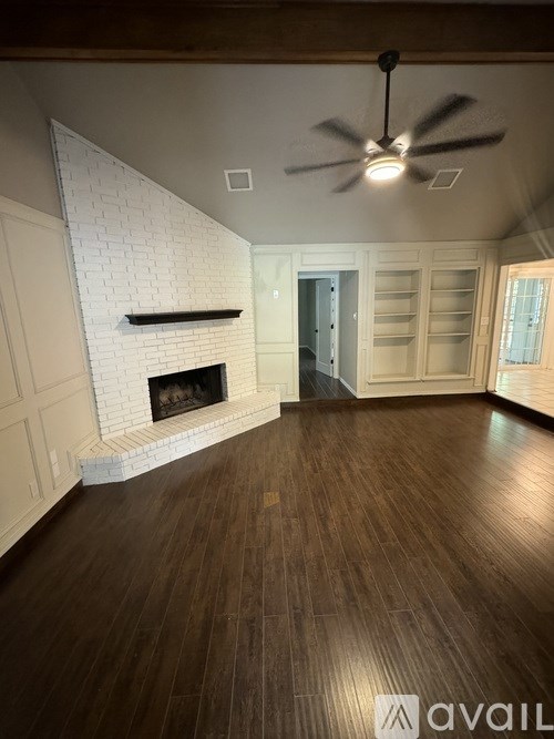 A room with a fireplace and a ceiling fan.
