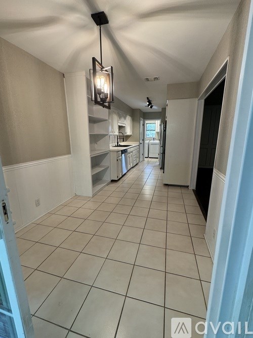 A long hallway with a light hanging from the ceiling.