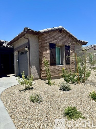 A house with a brown roof and a gravel driveway.