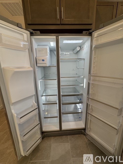 A white refrigerator with its door open is in a kitchen.