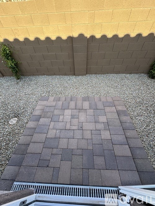 A small patio with a grey tiled floor and a white railing.