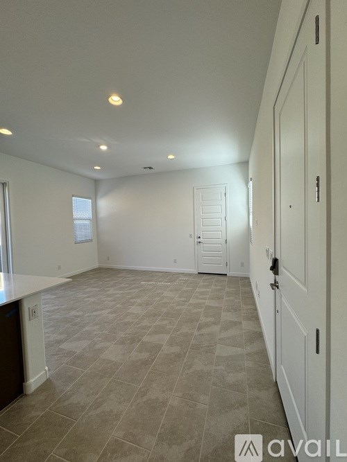 A large empty room with tiled flooring and white walls.