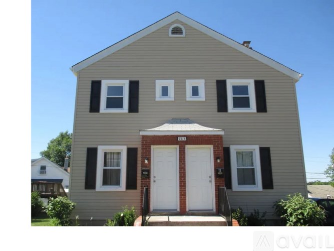 A two-story house with a red door and white trim.
