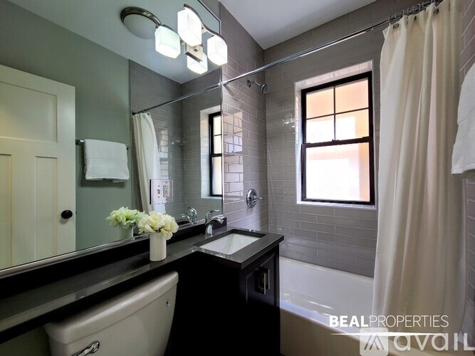 A bathroom with a sink, mirror, and shower.