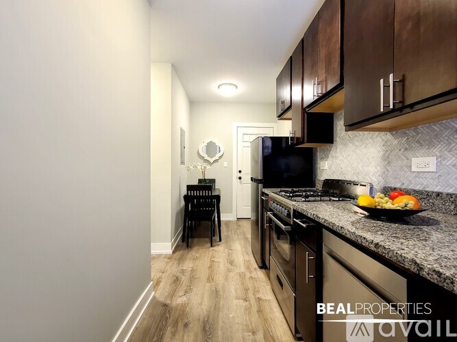 A kitchen with a black counter top and a black chair.