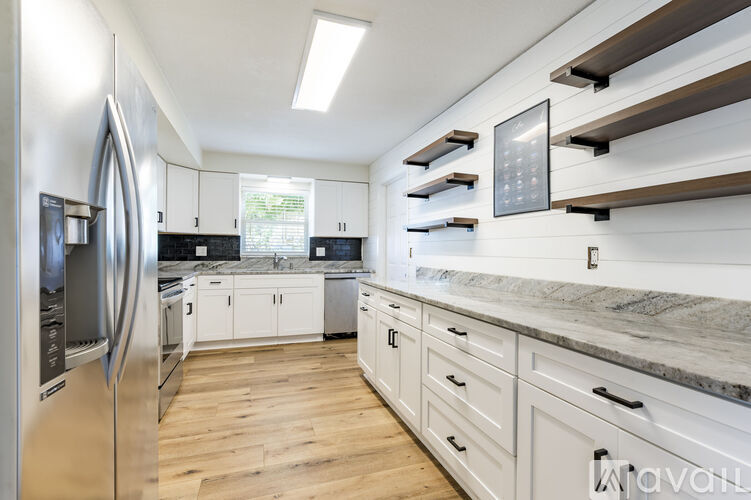 A modern kitchen with a refrigerator on the left and a countertop on the right.