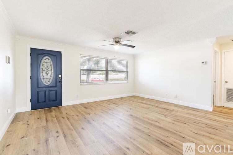 A room with a dark blue door and wooden flooring.