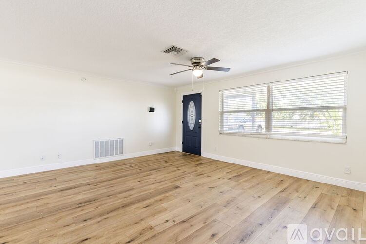 A room with wooden flooring and a ceiling fan.
