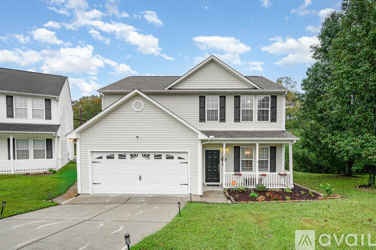 A house with a garage and a driveway is available for sale.
