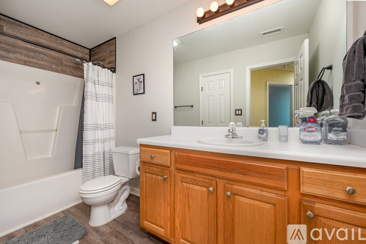 A bathroom with wooden cabinets and a white countertop.