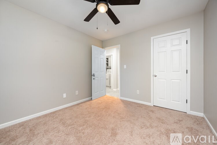 A room with a ceiling fan and two doors.