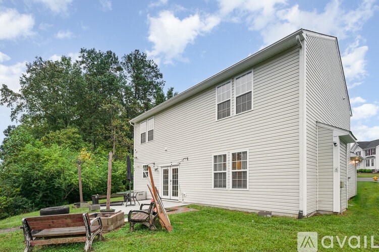 A house with a white siding and a small porch.