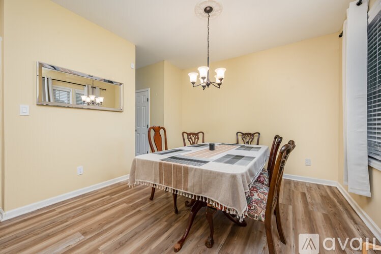 A dining room with a wooden table and chairs.