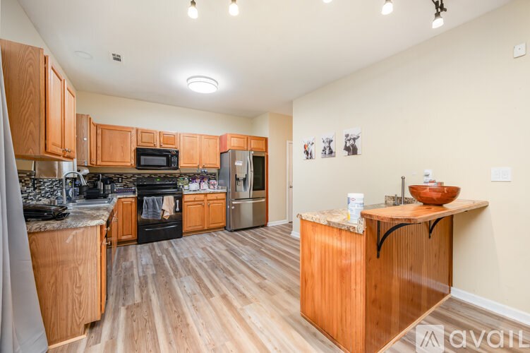 A kitchen with wooden cabinets and a black stove top oven.