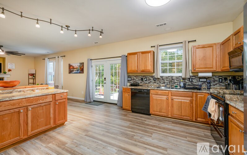 A kitchen with wooden cabinets and a marble countertop.
