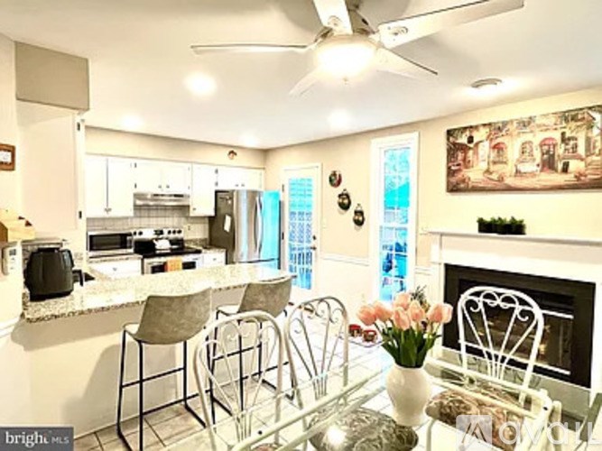 A kitchen with a table and chairs and a fireplace.