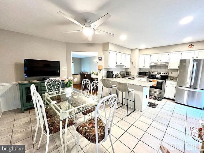 A kitchen with a dining table and chairs.