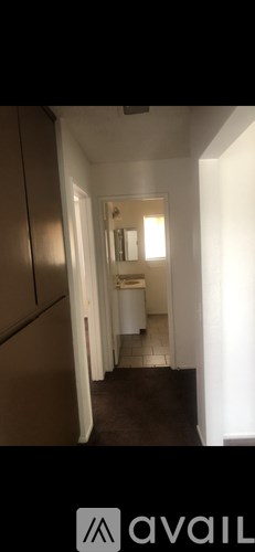 A hallway with a white door and a brown carpet.