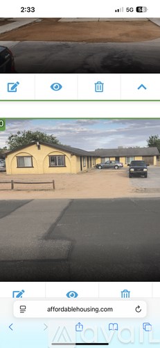 A mobile phone screen displaying a photo of a yellow house.