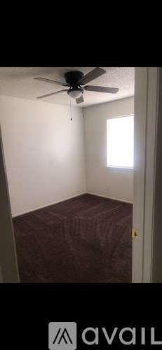 A room with a ceiling fan and a window.