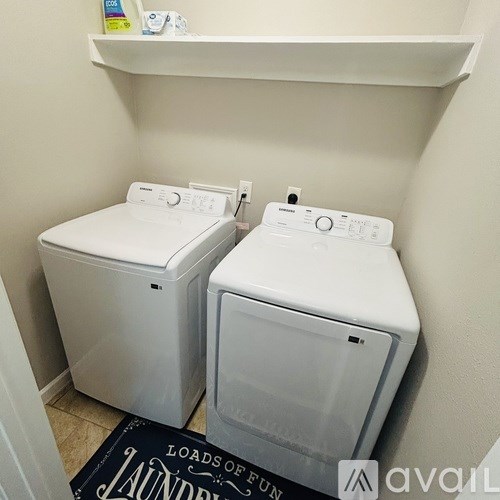 Two front loading washing machines in a small laundry room.