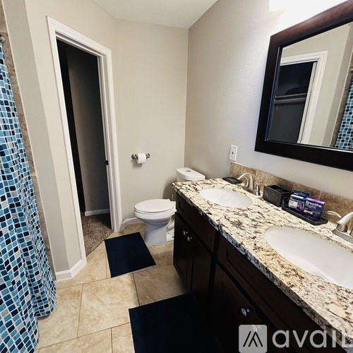 A bathroom with a toilet, sink, and shower.