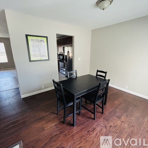A dining room with a black table and chairs.