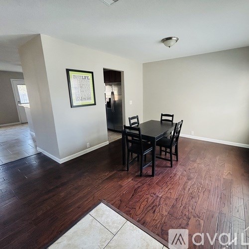 A dining room with a table and chairs.