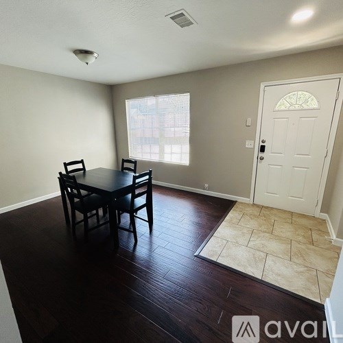 A dining room with a table and chairs.
