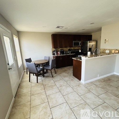 A kitchen with a table and chairs in the middle of the room.