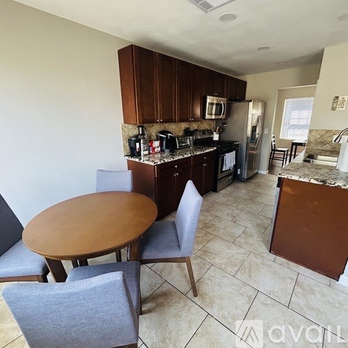 A kitchen with a table and chairs.