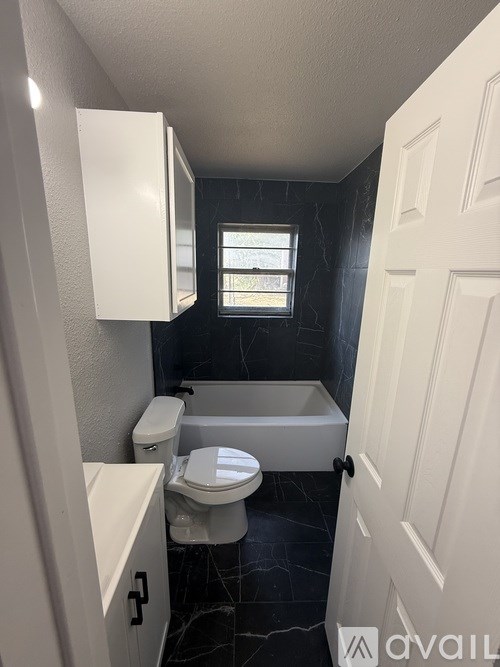 A small bathroom with a toilet, sink and bathtub.